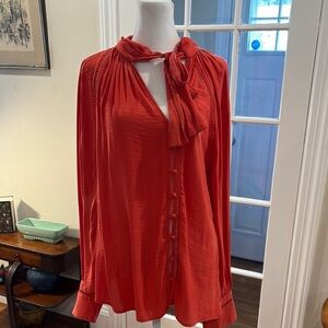 Free People orange blouse w/ fabric buttons down left side + tie at neck. Size M